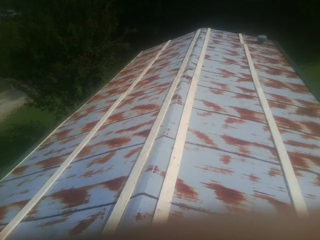 Rusted metal roof panels with new wood purlins before replacement — Storm Damage Roof Repair in Schnecksville by Roofing Brothers