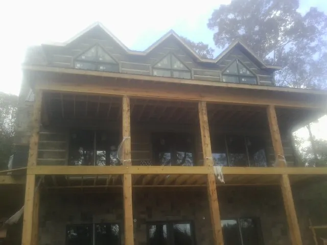 Dormers and porch framing on a large log home under construction — Roof Coating work by our crew in Schnecksville